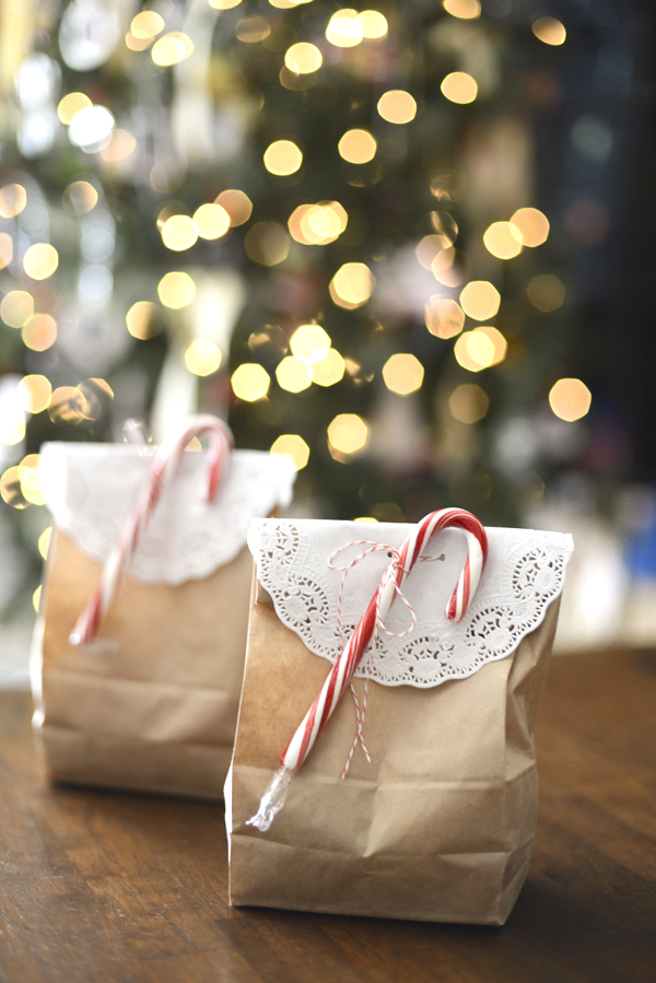 Simple Christmas gift wrapping idea using a brown paper bag, a doily, and a candy cane.