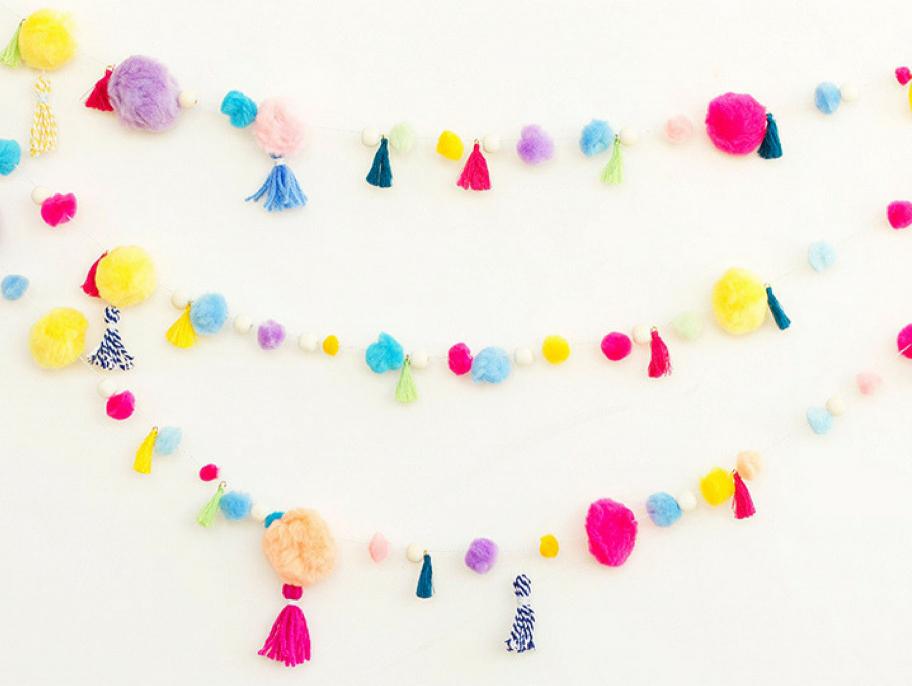 Pom pom and tassel party garland on a white backdrop